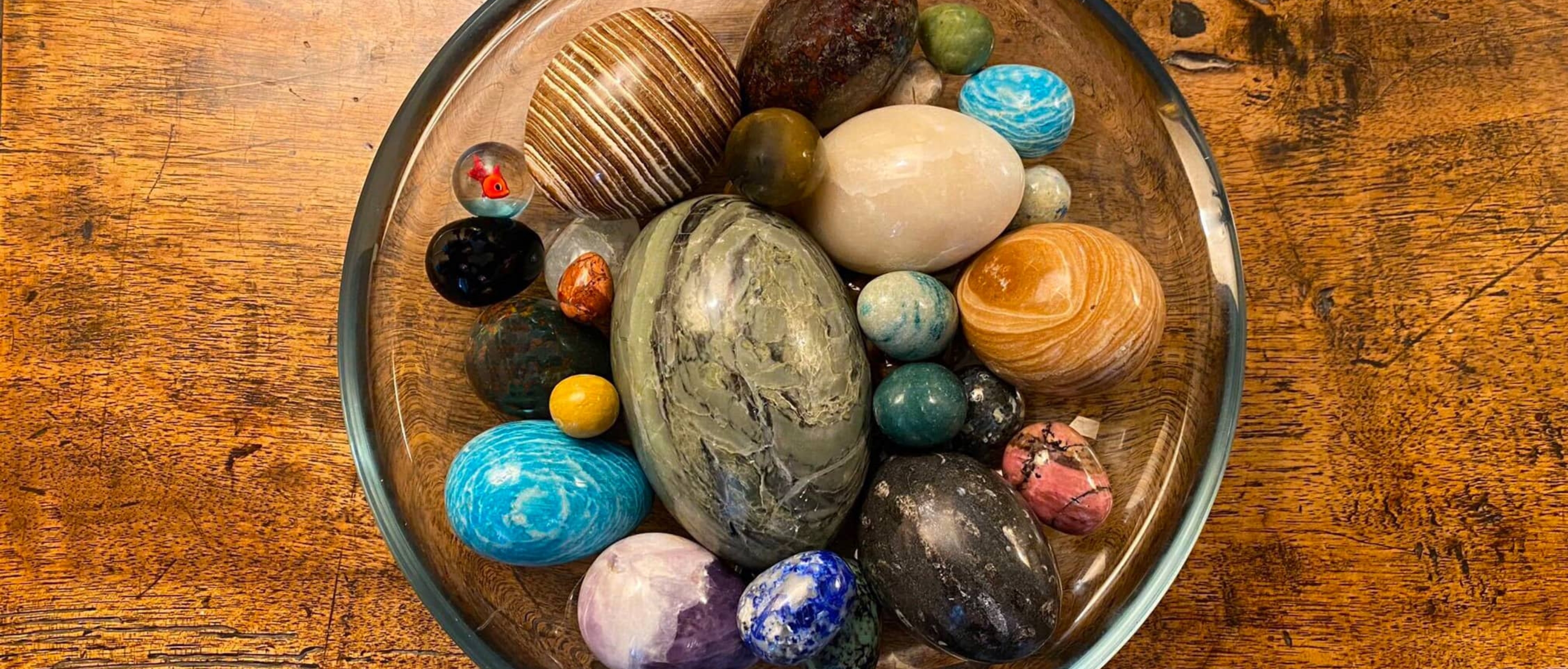 colourful marble eggs in glass bowl on wooden table