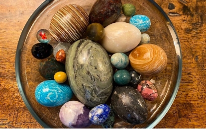 colourful marble eggs in glass bowl on wooden table